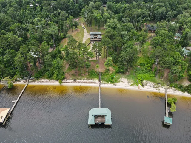 an aerial view of a house with swimming pool and outdoor seating