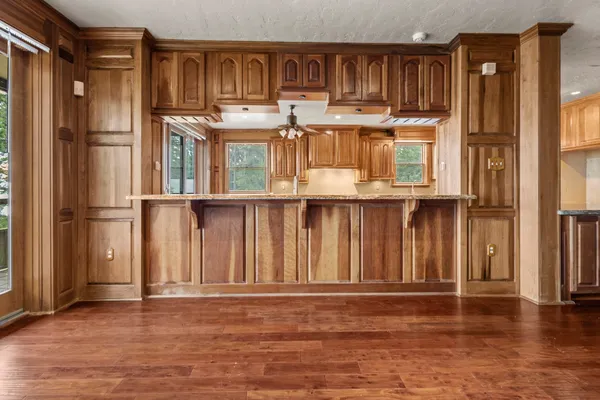 a view of a kitchen with wooden floor and a window
