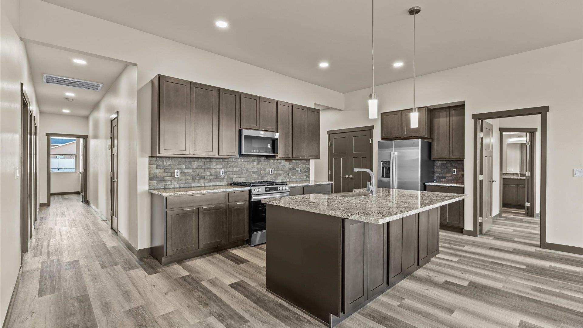 635 Anvil Way Grand Junction, CO 81504 - Photo 12 of 30 a kitchen with kitchen island granite countertop a sink stove and refrigerator