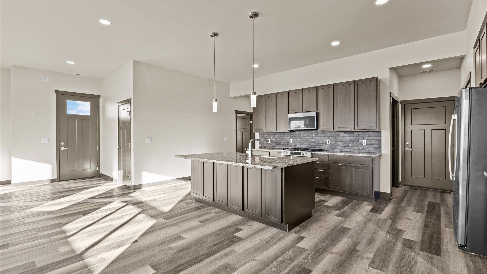635 Anvil Way Grand Junction, CO 81504 - Photo 13 of 30 a large kitchen with a sink a counter space stainless steel appliances and cabinets
