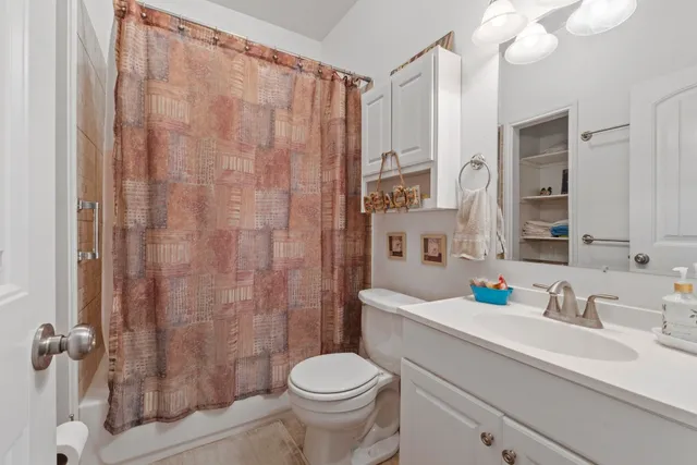 a bathroom with a sink a toilet and shower curtain
