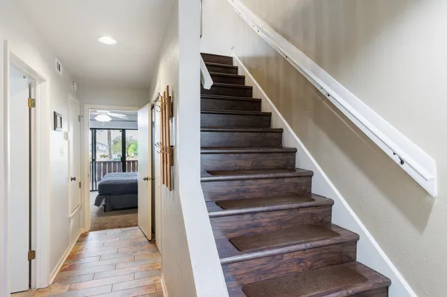 a living room with furniture kitchen view and a chandelier