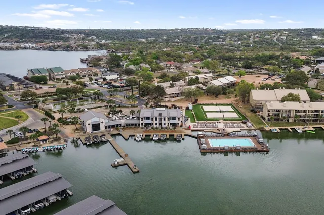 an aerial view of residential houses with outdoor space and lake view