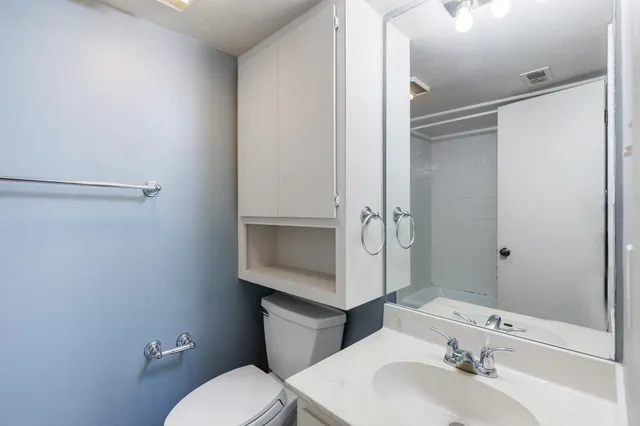 a bedroom with a large bed and a chandelier fan