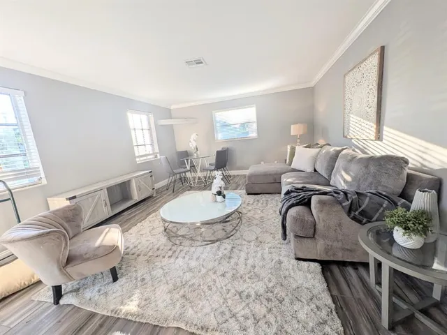 a living room with furniture and wooden floor