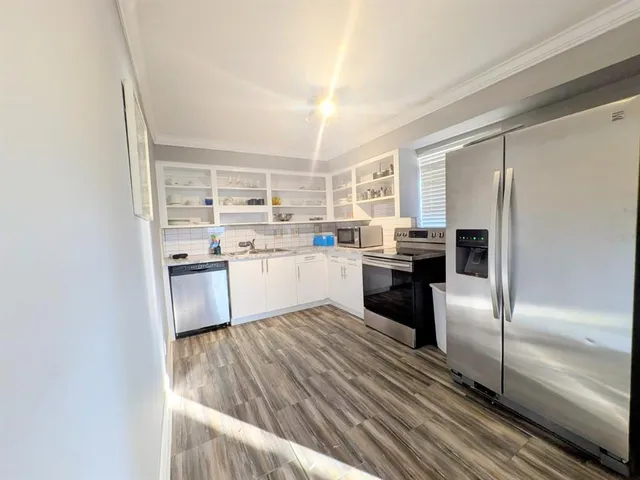 a kitchen with stainless steel appliances granite countertop a refrigerator sink and cabinets