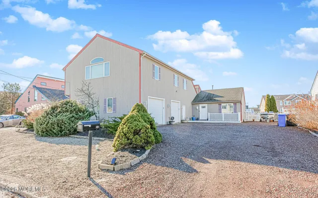a view of a house with a yard and table and chairs in front of it