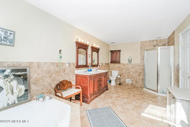 a spacious bathroom with 2 sink tub and a mirror