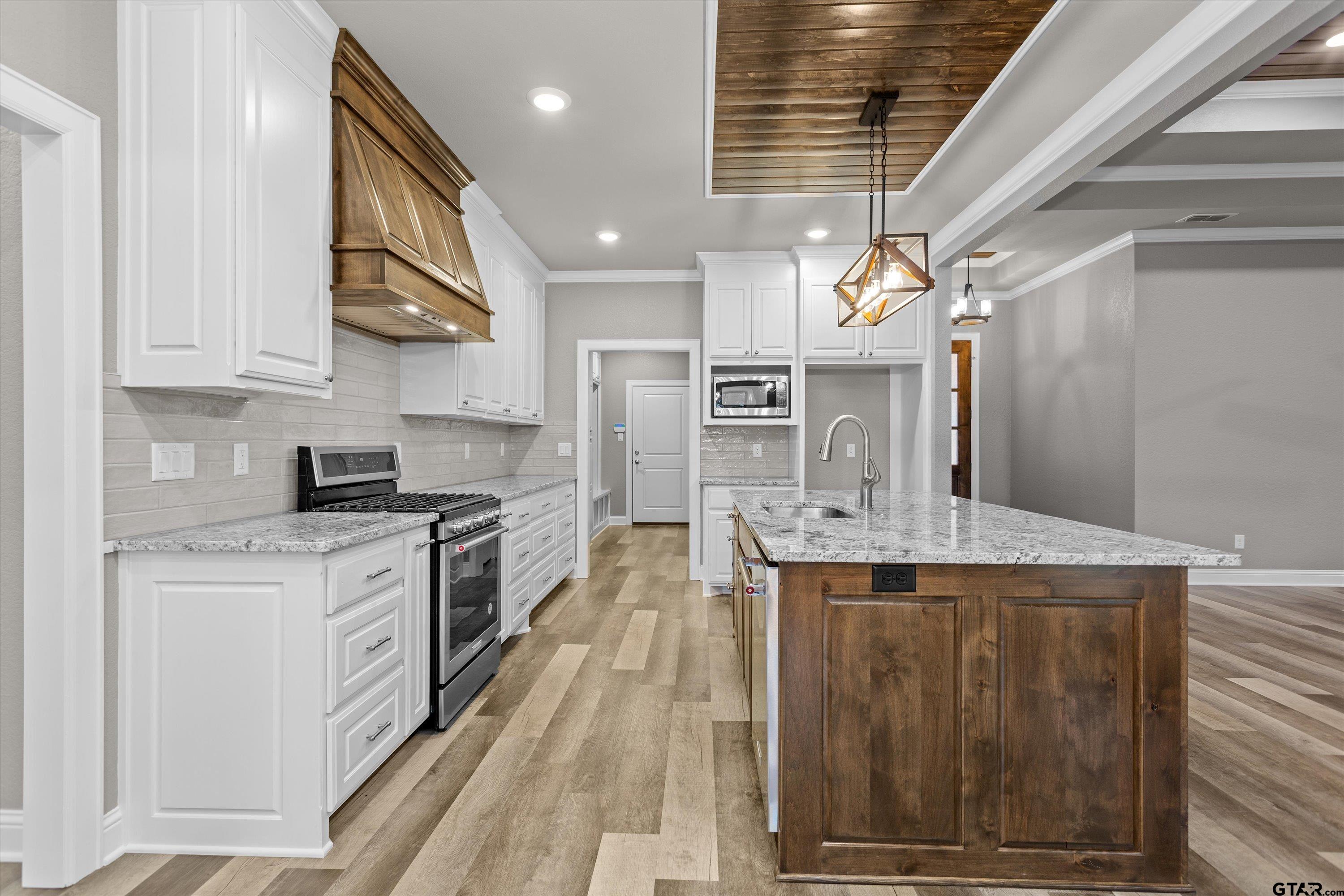 8527 Freestone Drive Bullard, TX 75757 - Photo 9 of 21 a large kitchen with stainless steel appliances granite countertop a stove and a sink