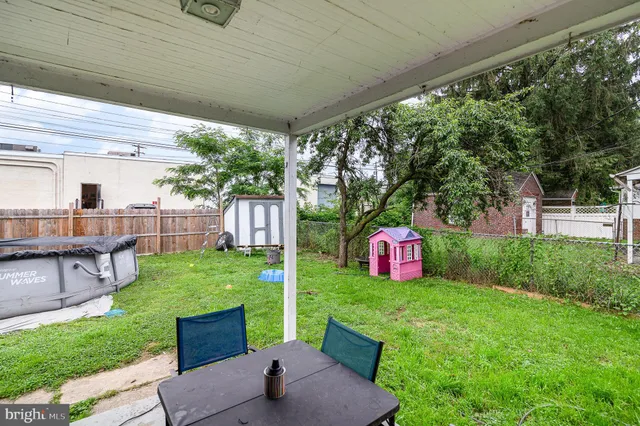 a view of a backyard with table and chairs and potted plants