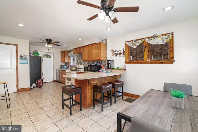 a kitchen with a dining table chairs and refrigerator