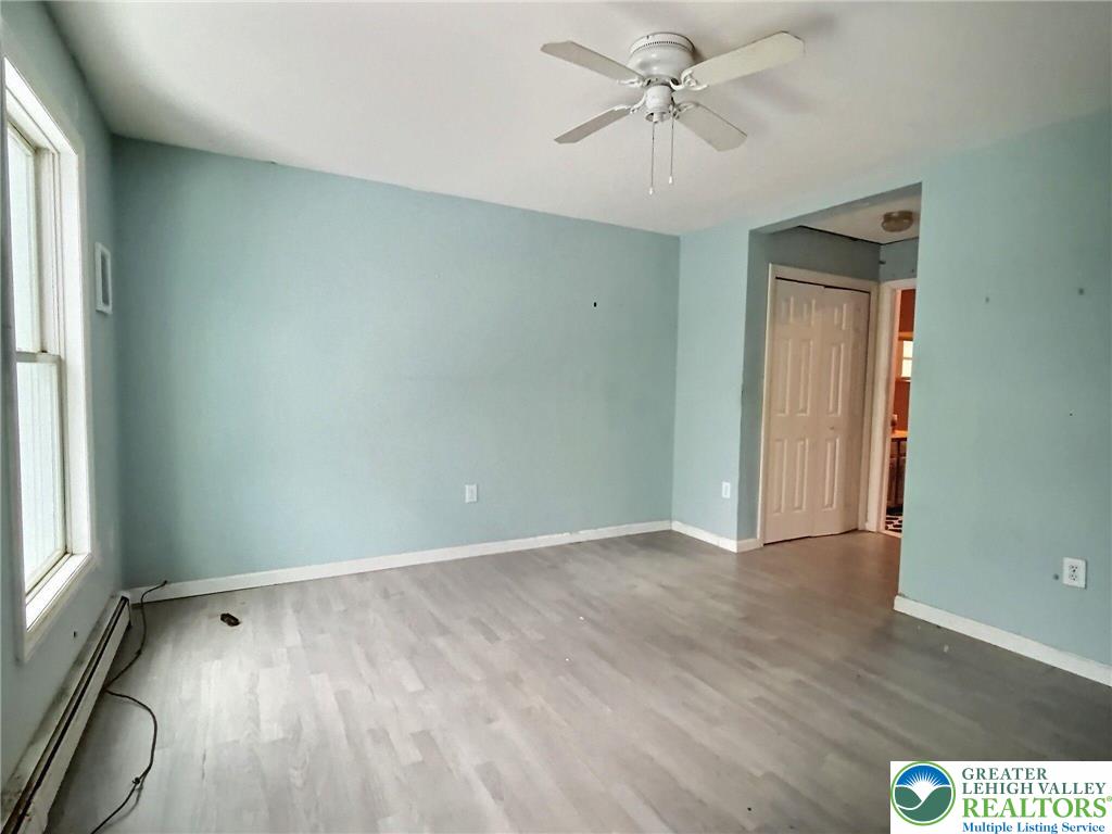 375 Marcel Drive Dingmans Ferry, PA 18328 - Photo 12 of 37 an empty room with wooden floor chandelier fan and windows