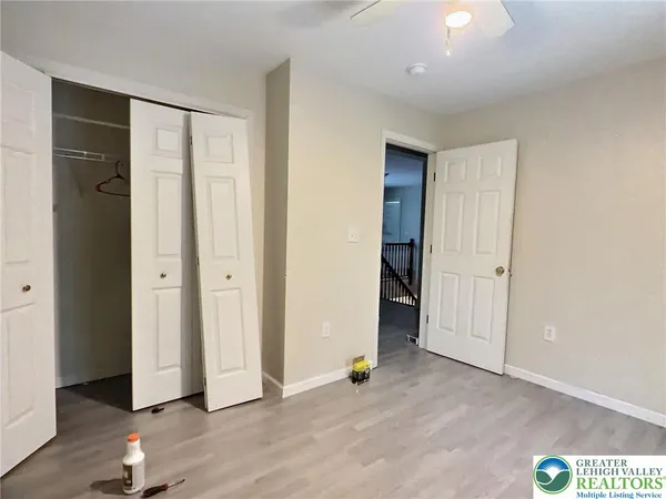 an empty room with wooden floor and closet