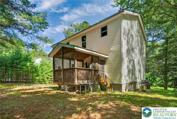 a view of house with yard and sitting area