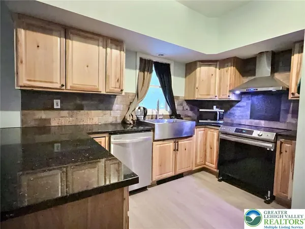 a kitchen with granite countertop a stove sink and cabinets
