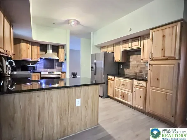 a kitchen with stainless steel appliances granite countertop a refrigerator a sink and white cabinets