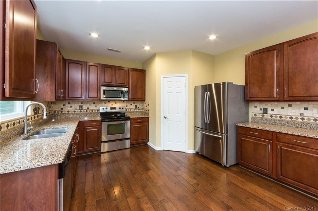 1132 Spicewood Pines Road Fort Mill, SC 29708 - Photo 12 of 24 a kitchen with granite countertop stainless steel appliances and wooden cabinets