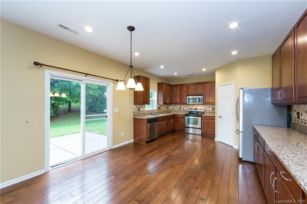 1132 Spicewood Pines Road Fort Mill, SC 29708 - Photo 10 of 24 a large kitchen with a center island wooden floor stainless steel appliances and cabinets