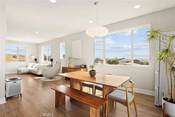 a living room with furniture kitchen view and a large window