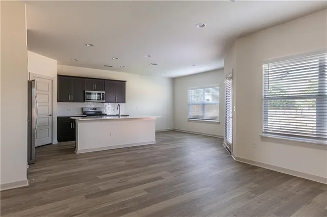 a view of kitchen with microwave refrigerator and cabinets