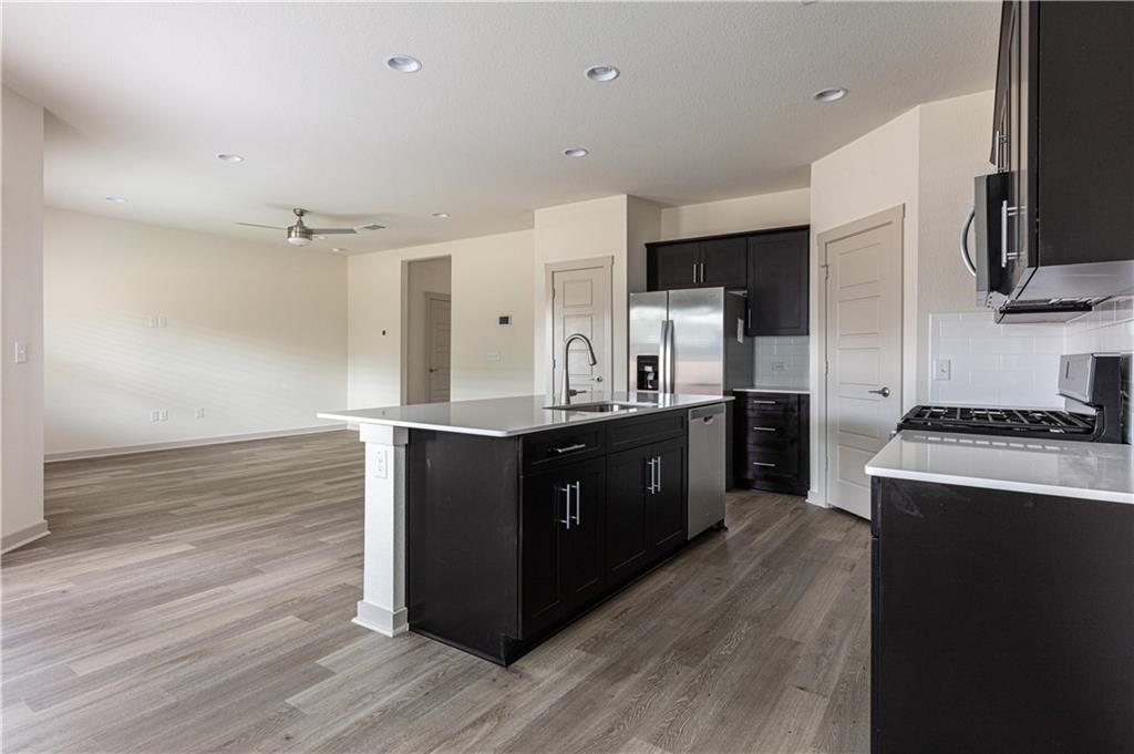 1801 Bonham Lane Round Rock, TX 78664 - Photo 8 of 24 a kitchen with stainless steel appliances granite countertop a stove a sink and a refrigerator