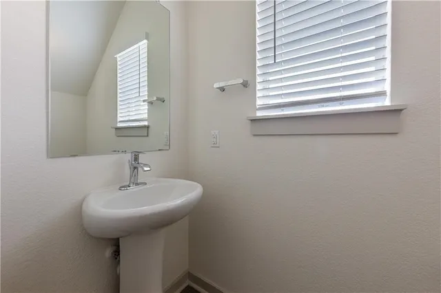 a bathroom with a sink a mirror and a window