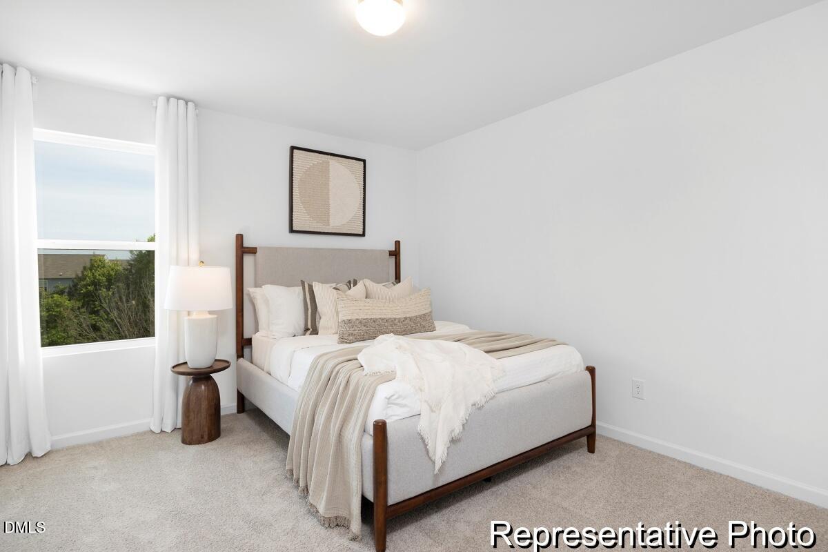 47 Flicker Lane, Unit 188P Angier, NC 27501 - Photo 24 of 38 a large bed sitting in a bedroom next to a window