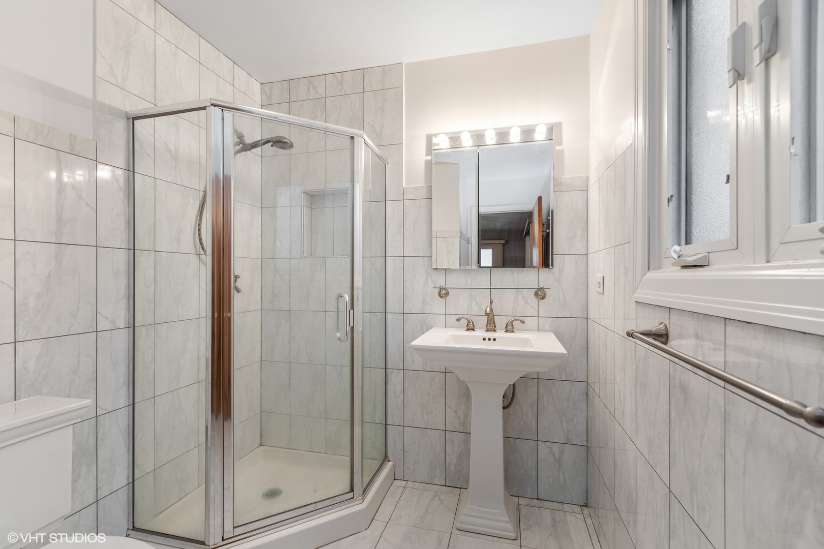 7604 Beckwith Road Morton Grove, IL 60053 - Photo 10 of 20 a bathroom with a shower a mirror and a sink