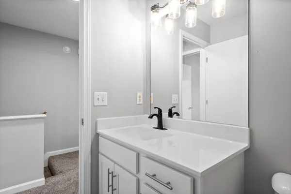 a bathroom with a sink vanity and a toilet