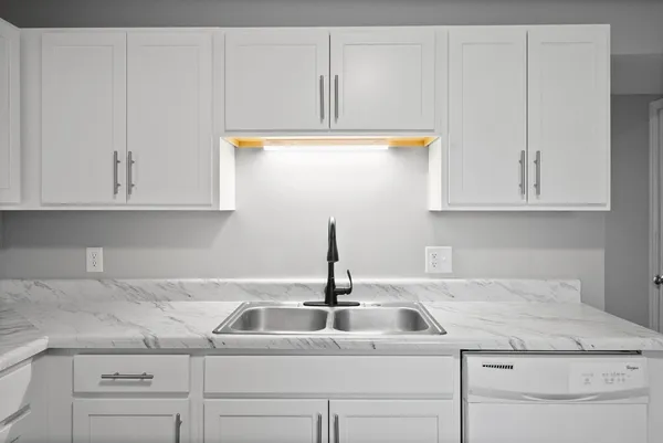 a kitchen with white cabinets and a sink