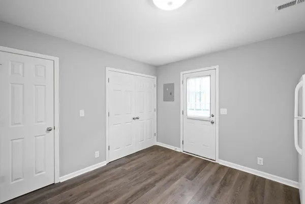 a view of an empty room with wooden floor