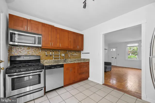 a kitchen with stainless steel appliances granite countertop a stove microwave and cabinets