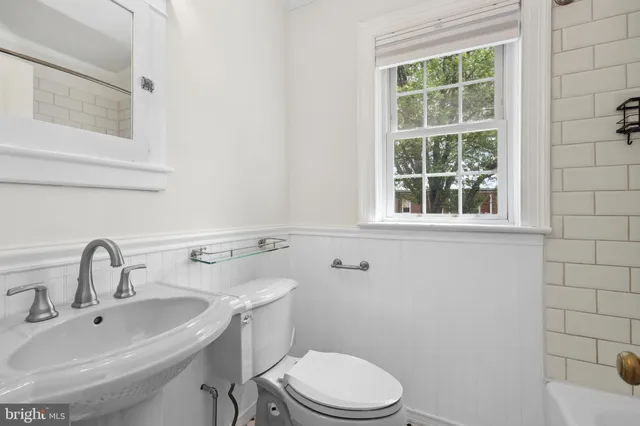 a bathroom with a sink toilet and mirror