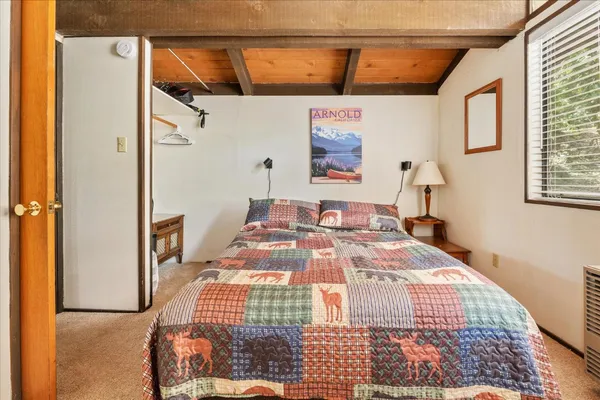 a bedroom with a bed dresser and window