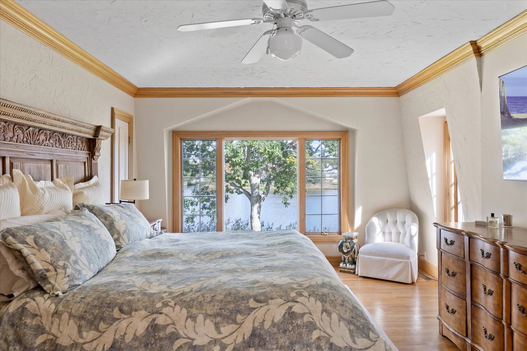 25 Quantuck Bay Lane Westhampton Beach, NY 11978 - Photo 26 of 38 a bedroom with a large bed and a chandelier