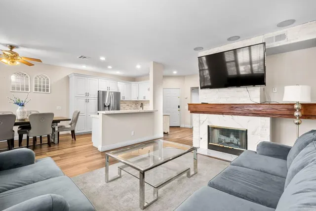 a living room with furniture a flat screen tv and a fireplace