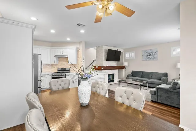 a living room with furniture a flat screen tv and kitchen view
