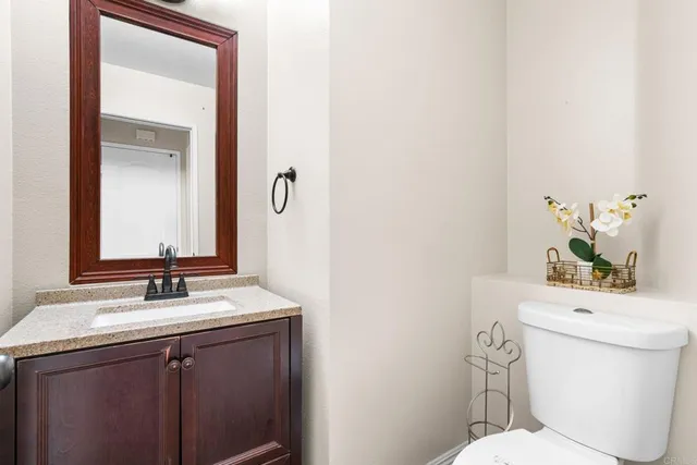 a bathroom with a sink vanity mirror and toilet