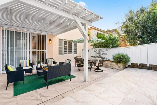 a view of a patio with couches table and chairs and potted plants
