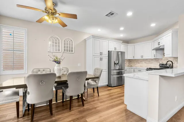 a living room with stainless steel appliances kitchen island granite countertop furniture and a refrigerator
