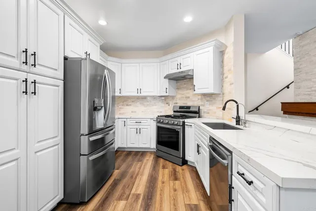 a kitchen with granite countertop a refrigerator stove and sink