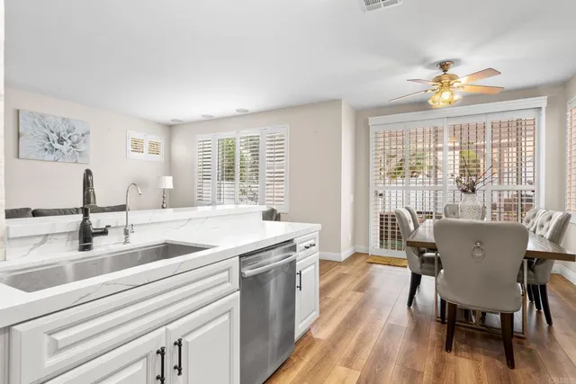 a view of a dining room with furniture a chandelier and wooden floor