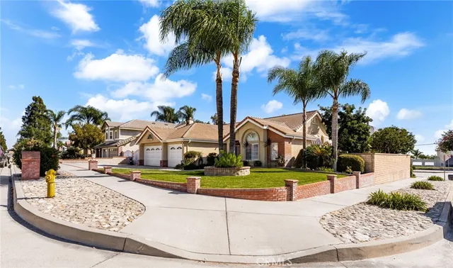 a view of a white house with a yard and potted plants