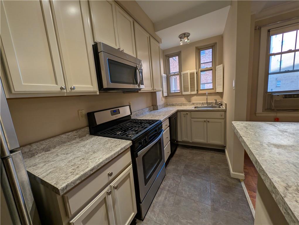 144 North Dithridge Street, Unit 403 Pittsburgh, PA 15213 - Photo 3 of 31 a kitchen with stainless steel appliances granite countertop a stove a sink and a microwave