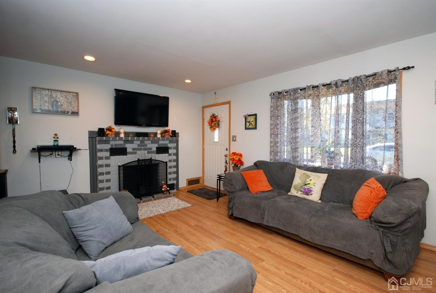 18 Crescent Road Edison, NJ 08817 - Photo 6 of 28 a living room with furniture a flat screen tv and a fireplace