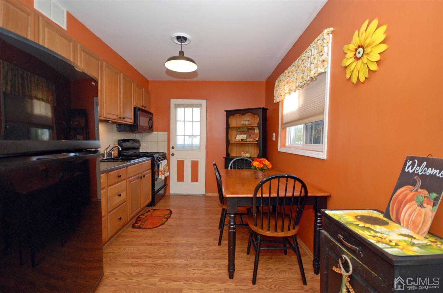 18 Crescent Road Edison, NJ 08817 - Photo 10 of 28 a kitchen with stainless steel appliances granite countertop a stove a refrigerator a microwave a dining table and chairs with wooden floor