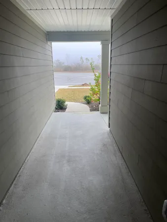 a view of a room with a door and wooden floor