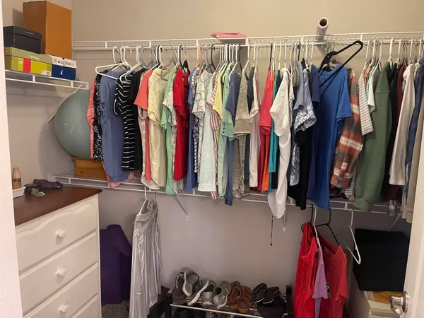 a view of walk in closet with clothes and shoes
