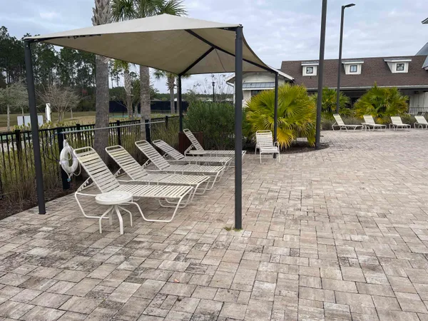 a view of a patio with a table and chairs under an umbrella