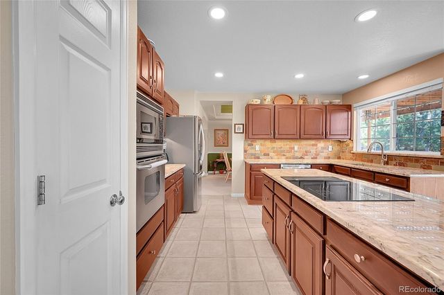 a kitchen with stainless steel appliances granite countertop a sink and a stove top oven